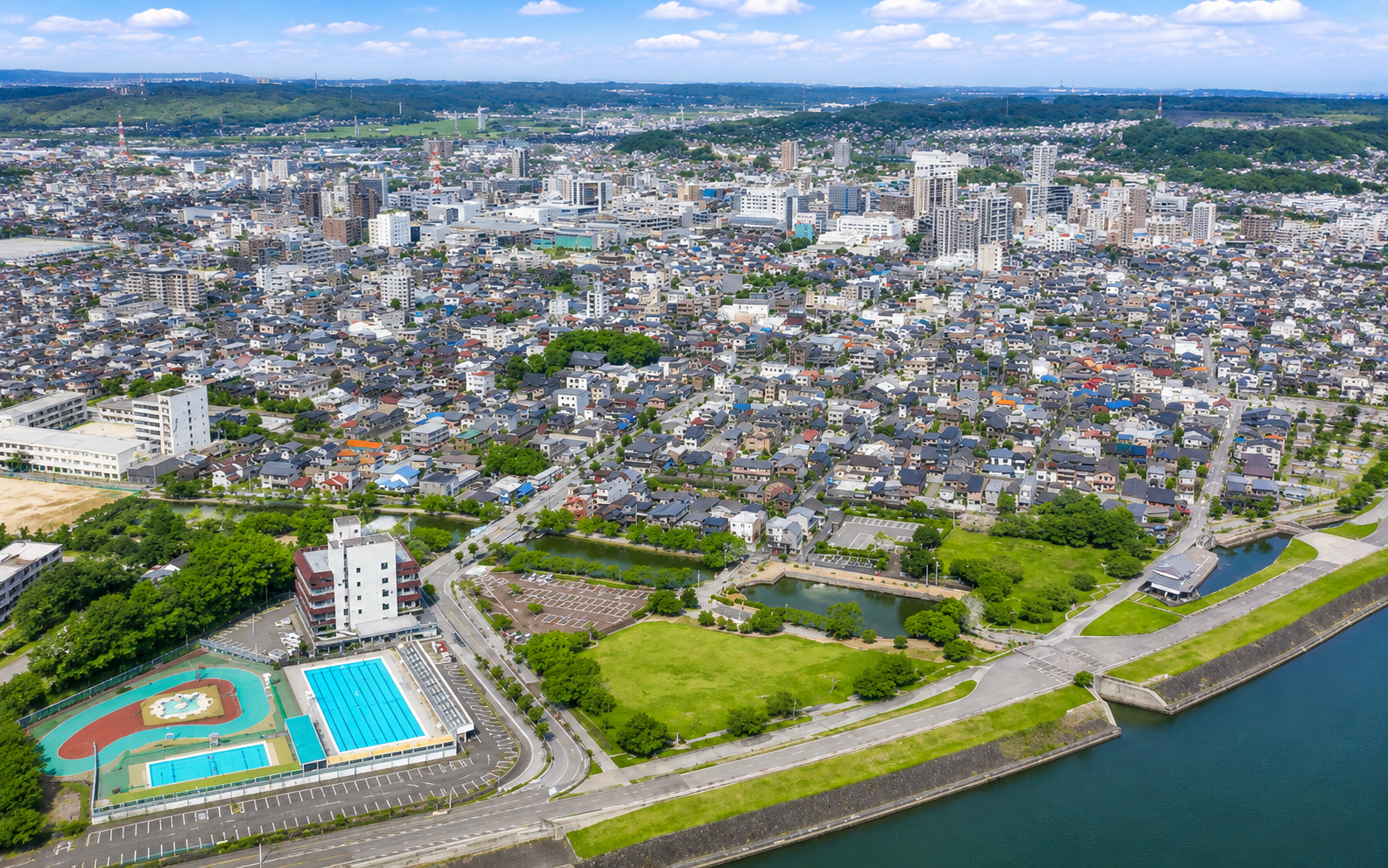 山林、街、学校、施設、公園と緑が見える地域の風景